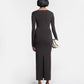 Woman wearing a black dress with a slit on a white background