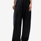 Person wearing black wide-leg pants on a white background