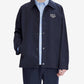 Navy blue shirt with a brand logo on a light gray background
