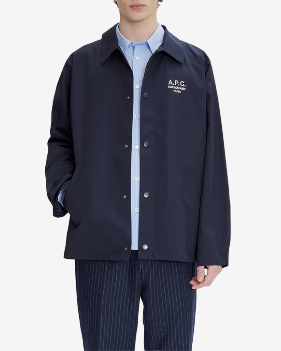Navy blue shirt with a brand logo on a light gray background
