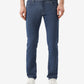 Person wearing blue jeans and a green shirt on a white background