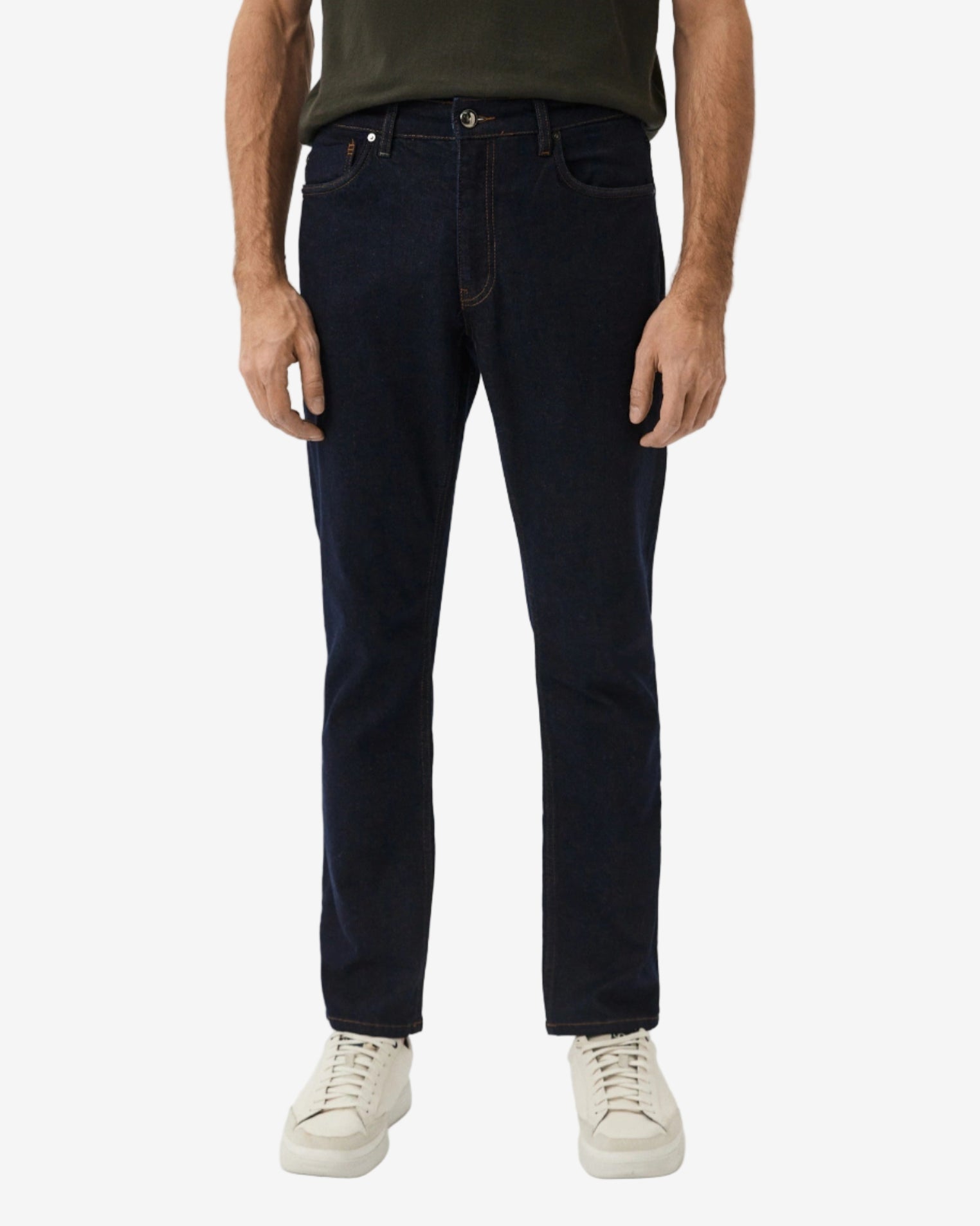 Person wearing dark jeans and a green shirt on a white background