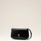 Person holding a black handbag with a gold emblem against a neutral background ami paris