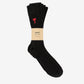 Black sock with a red heart design and 'ami' label on a light gray background