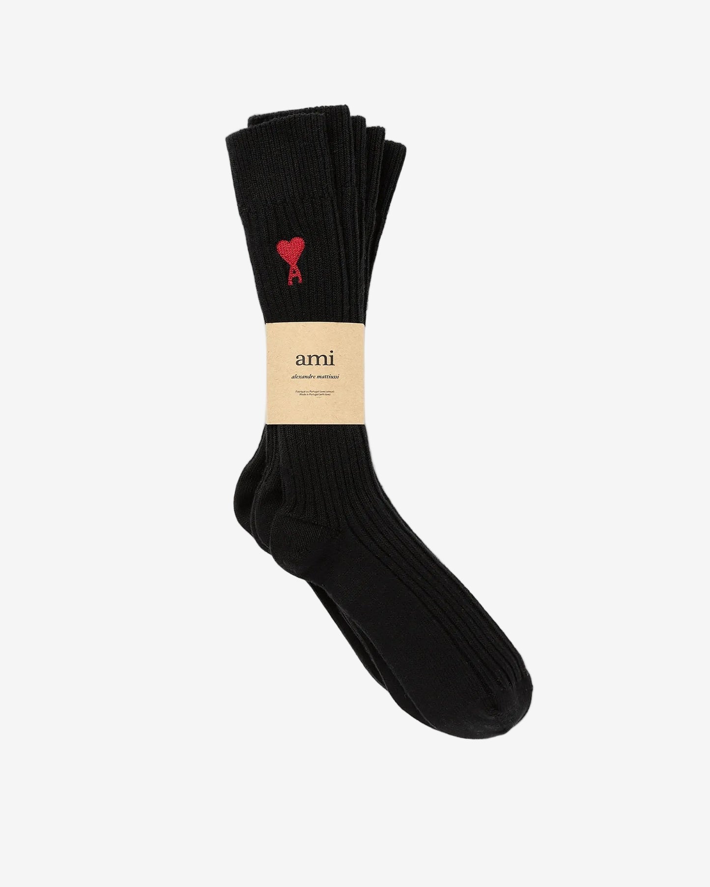 Black sock with a red heart design and 'ami' label on a light gray background