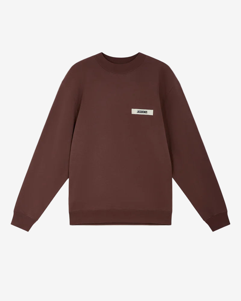 Brown sweatshirt with a small logo on a white background