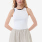 Woman wearing a white sleeveless top and beige shorts on a white background