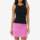 Woman wearing a black top and pink skirt on a white background