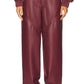 Maroon leather pants worn by a person on a white background