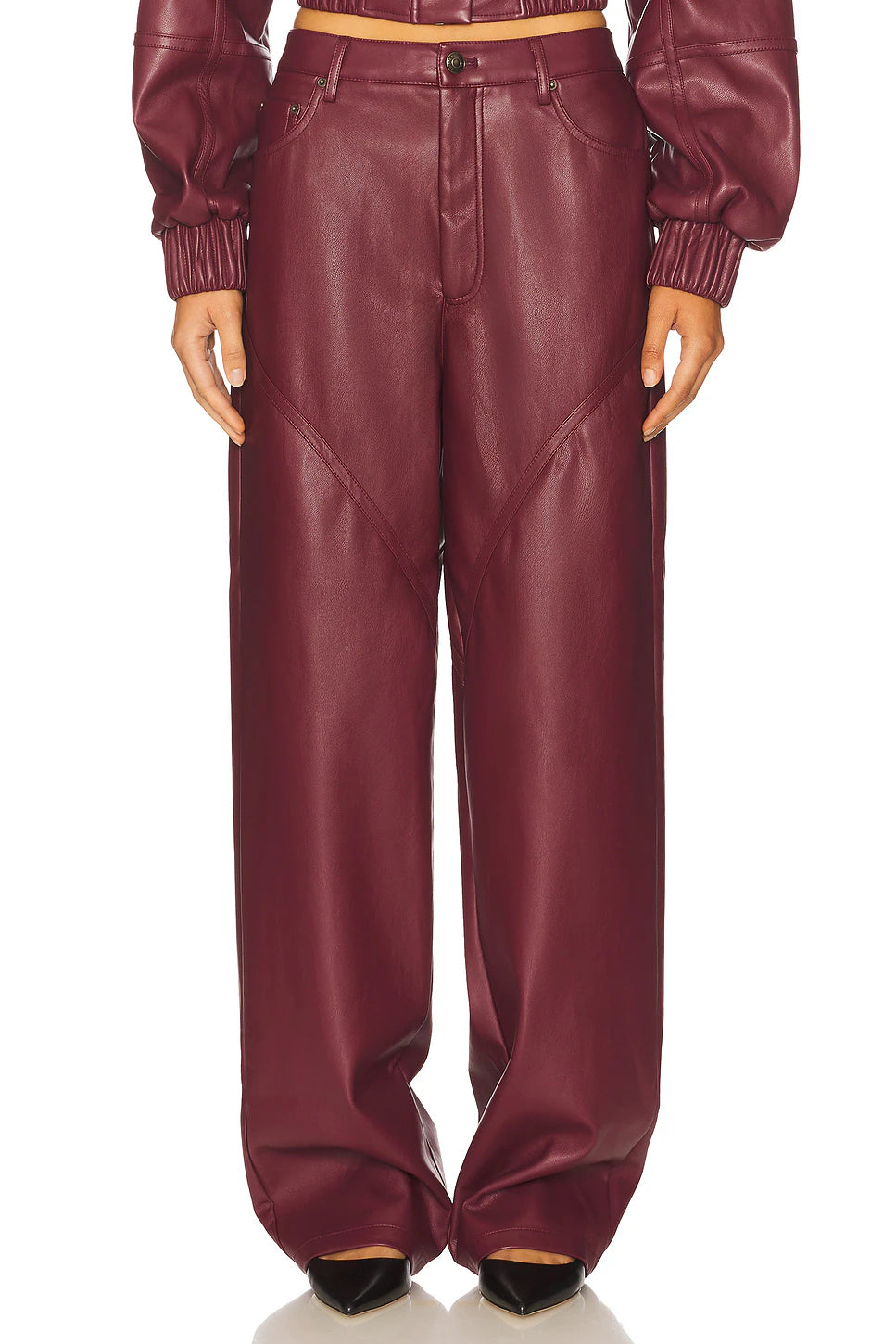 Maroon leather pants worn by a person on a white background