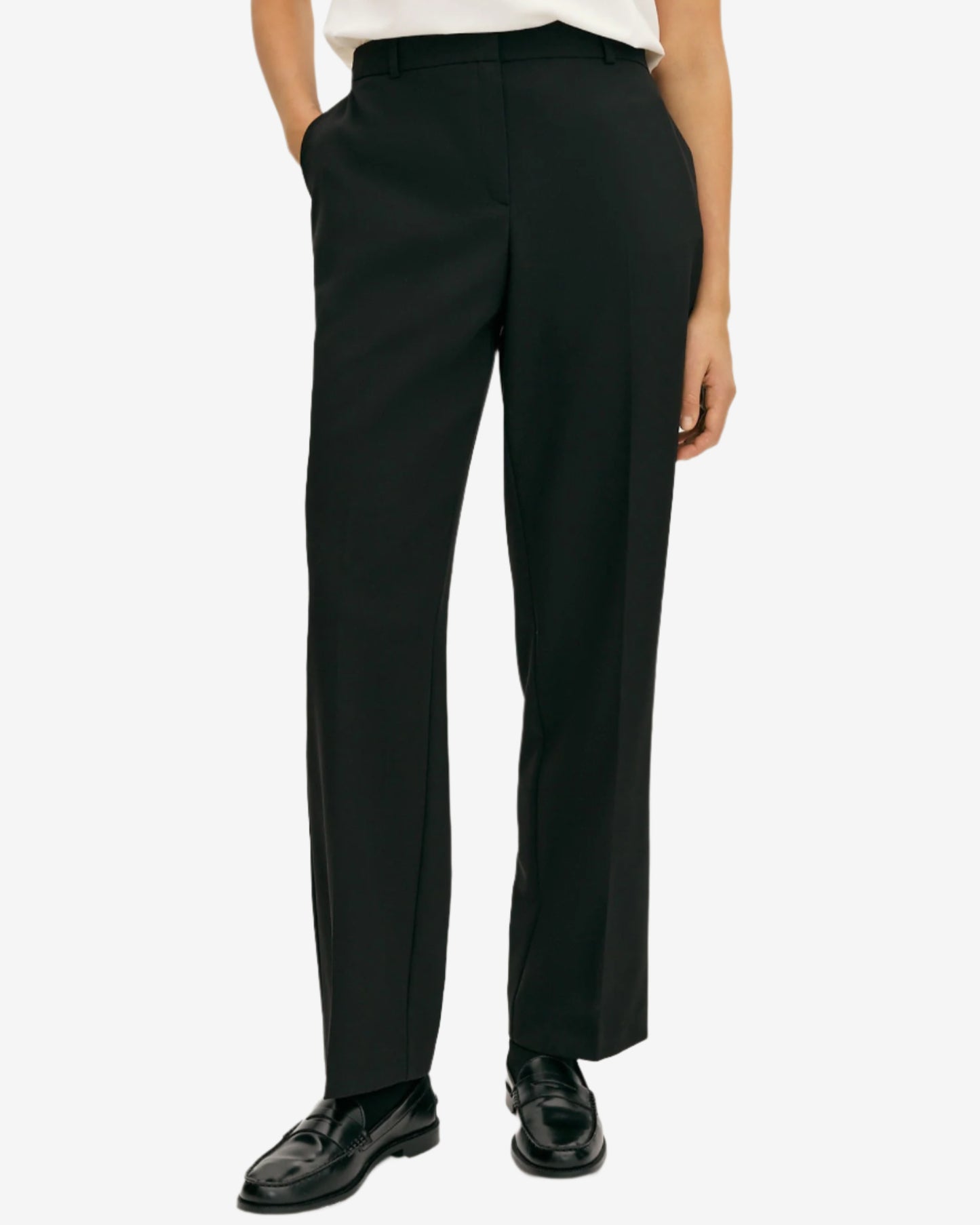 Person wearing black pants and black shoes on a white background