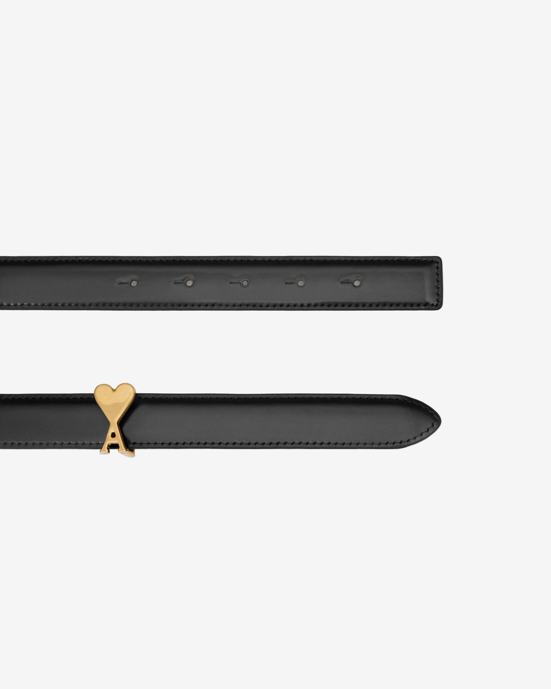 Black belt with a gold heart emblem on a beige background