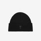 Black beanie hat on a light beige background