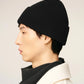 Black beanie hat on a light beige background