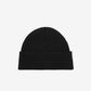 Black beanie hat on a light beige background