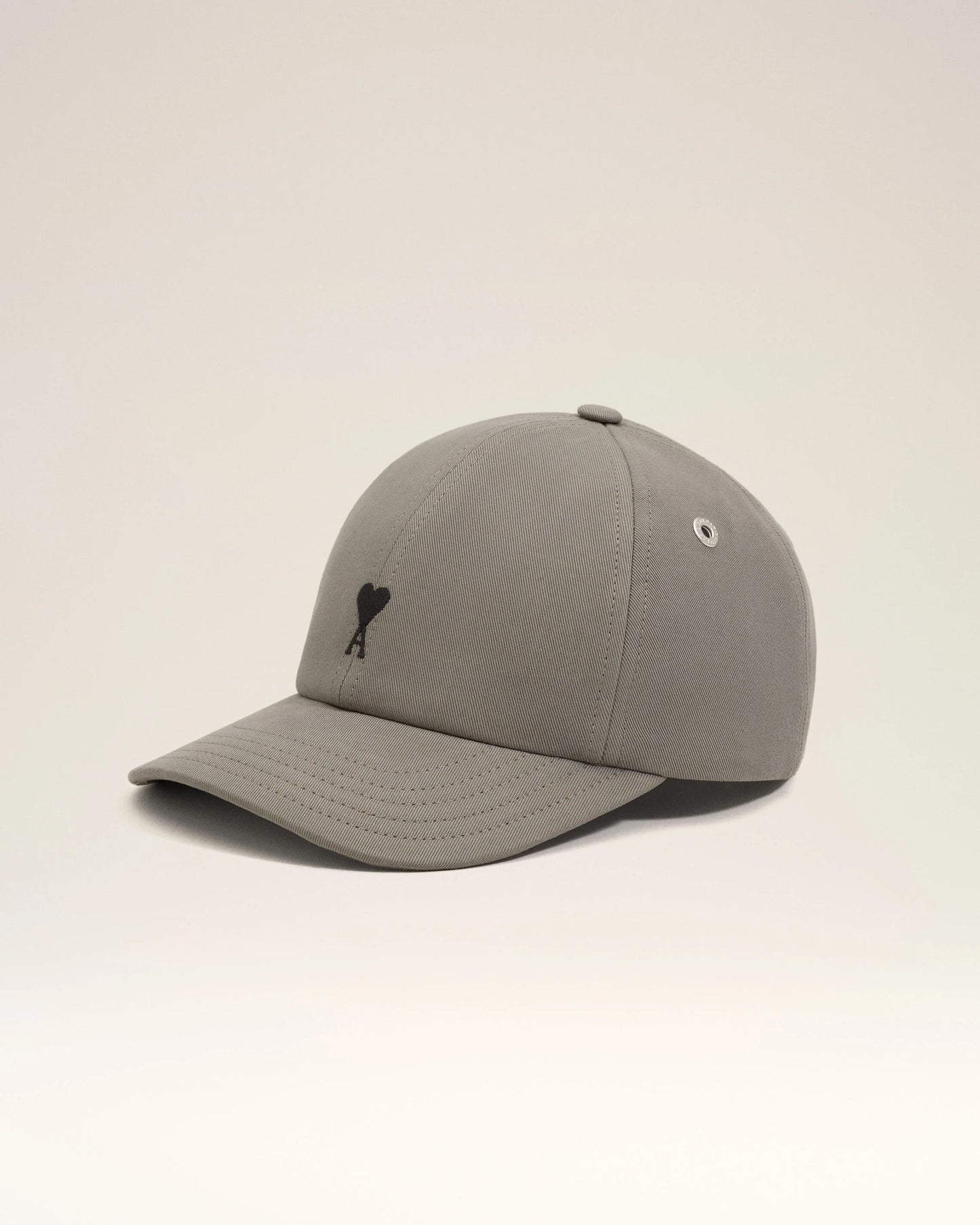 Gray cap with a black logo on a beige background ami paris