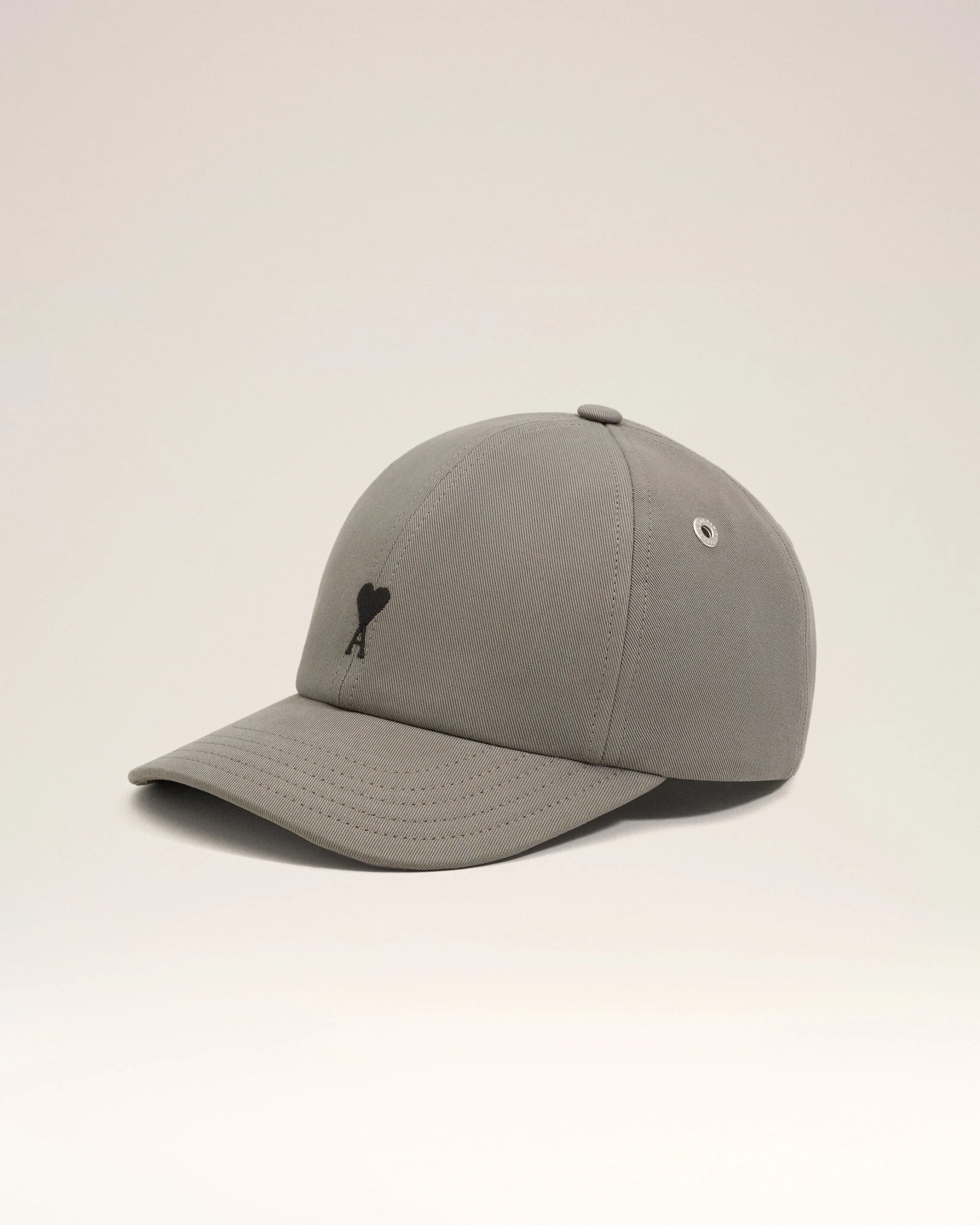 Gray cap with a black logo on a beige background ami paris