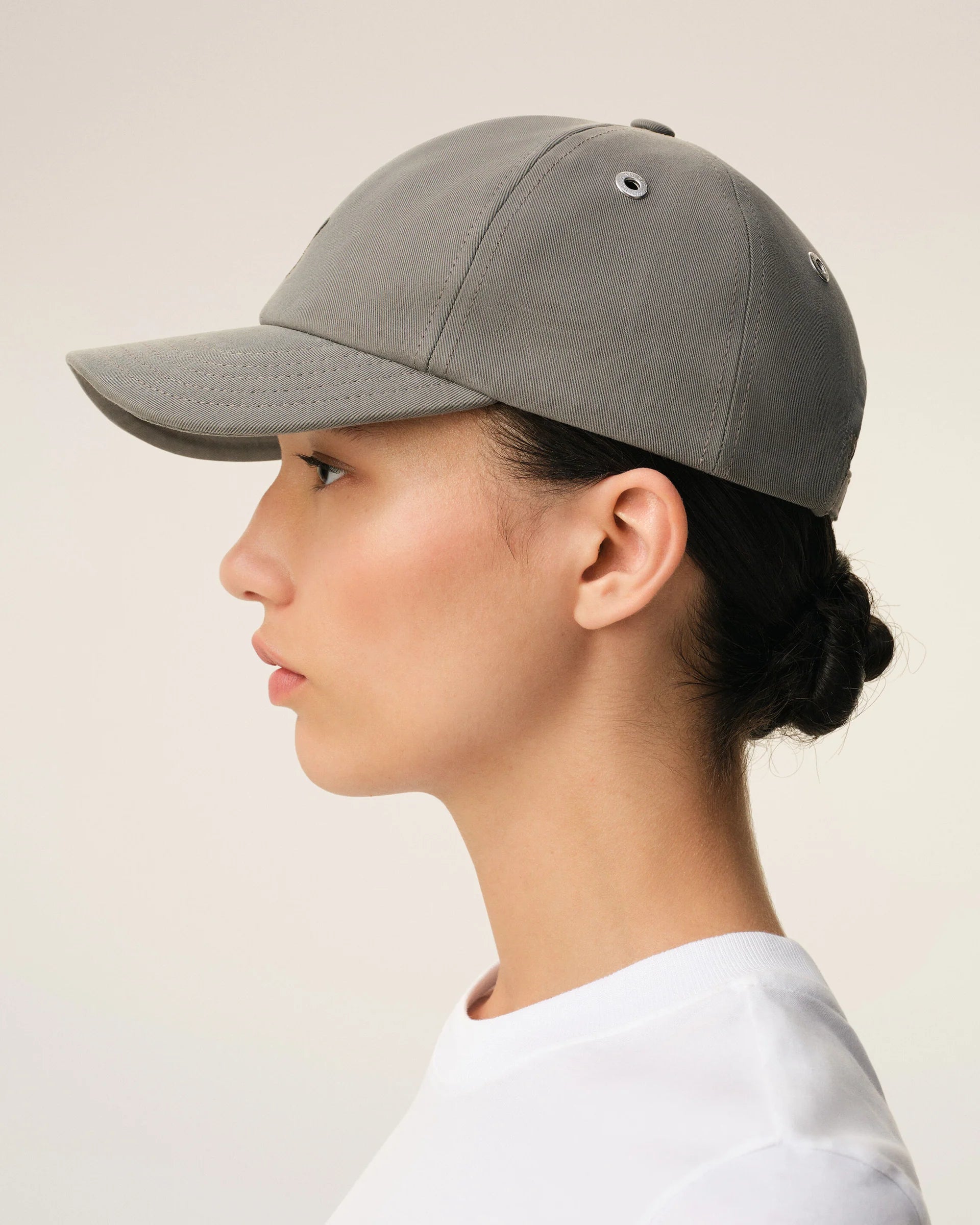 Gray cap with a black logo on a beige background ami paris