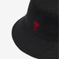 Black bucket hat with a red heart design on a beige background