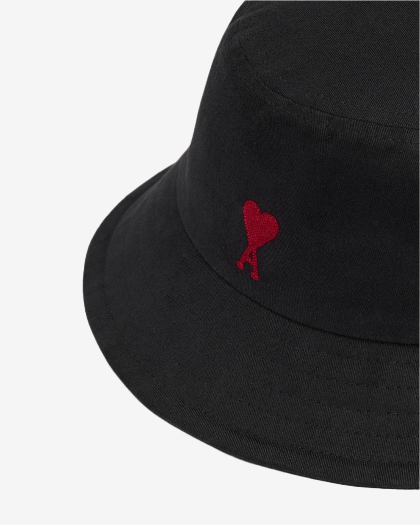 Black bucket hat with a red heart design on a beige background