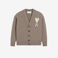 Brown cardigan with a heart and 'AMI' logo on a beige background
