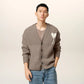 Brown cardigan with a heart and 'AMI' logo on a beige background