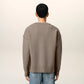 Brown cardigan with a heart and 'AMI' logo on a beige background