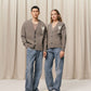 Brown cardigan with a heart and 'AMI' logo on a beige background