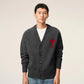 Dark gray cardigan with a red heart emblem on a beige background ami paris