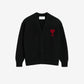 Black cardigan with a red heart emblem on a beige background ami paris