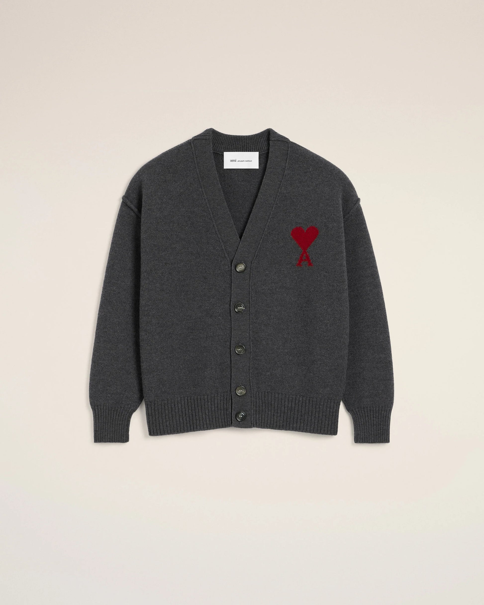 Dark gray cardigan with a red heart emblem on a beige background ami paris