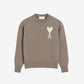 Brown sweater with a logo on a beige background
