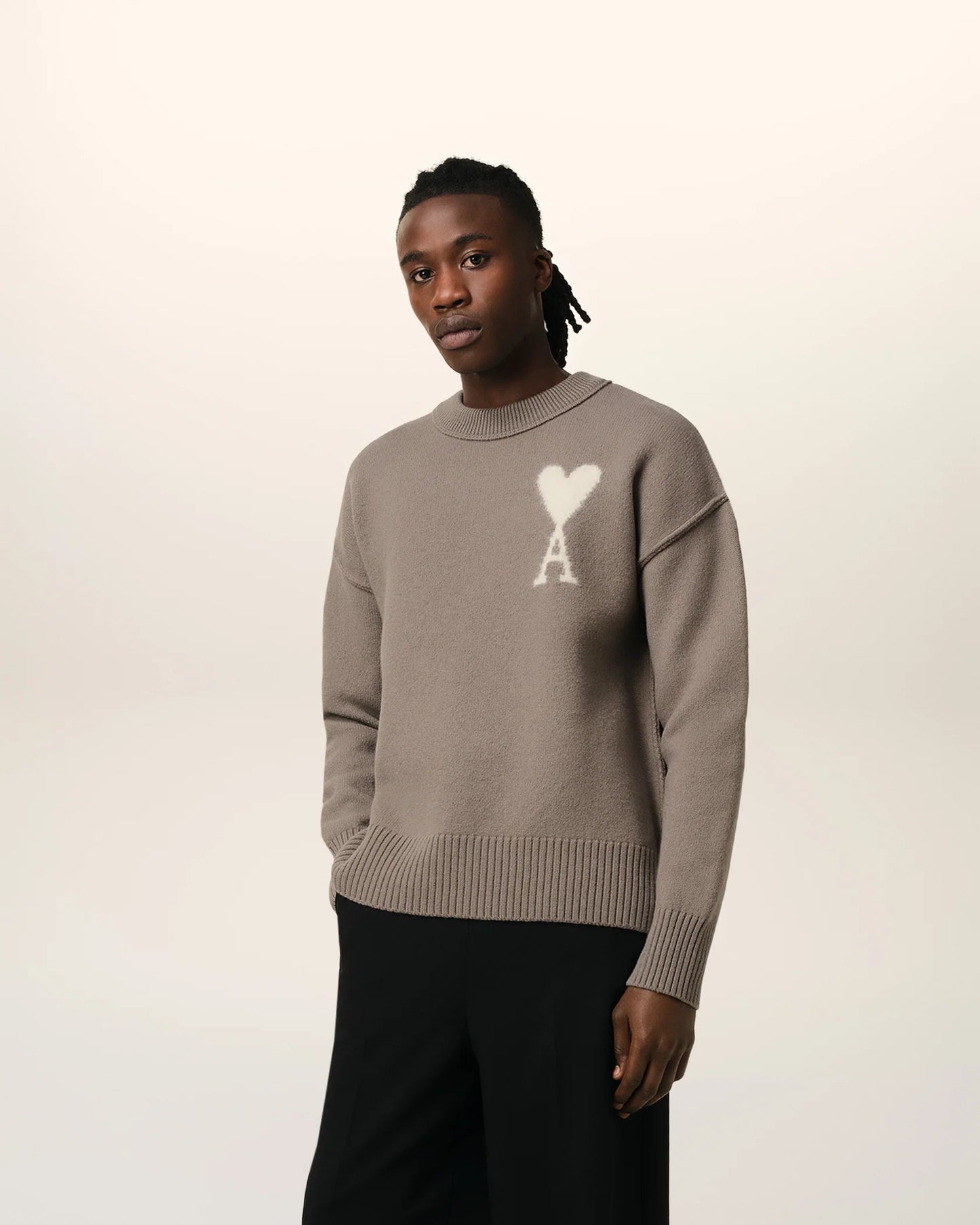 Brown sweater with a logo on a beige background