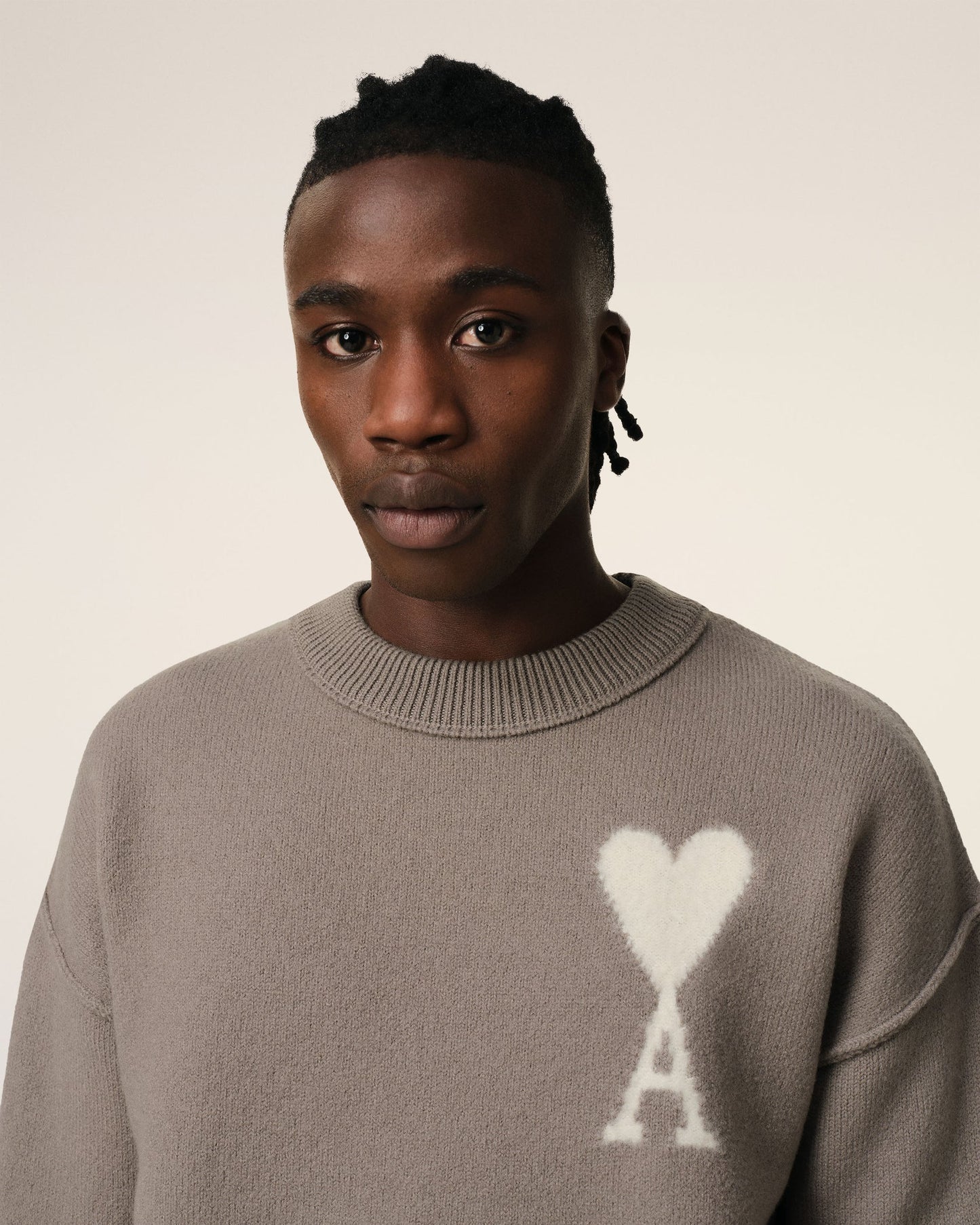 Brown sweater with a logo on a beige background