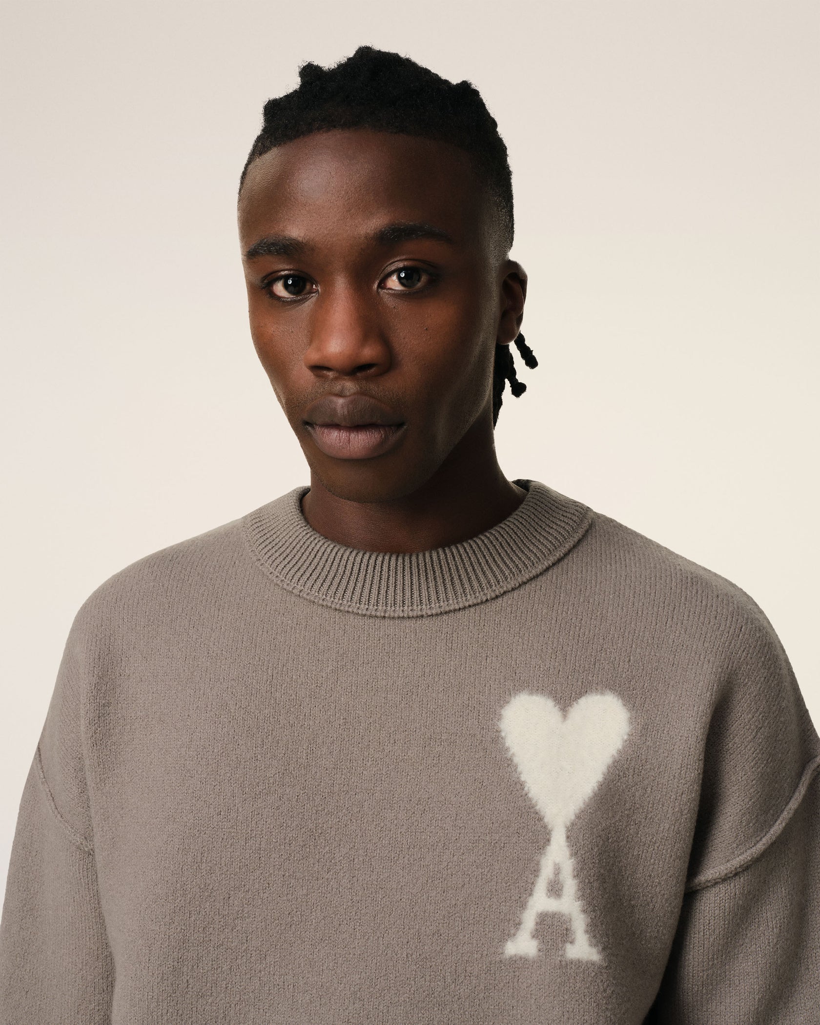Brown sweater with a logo on a beige background