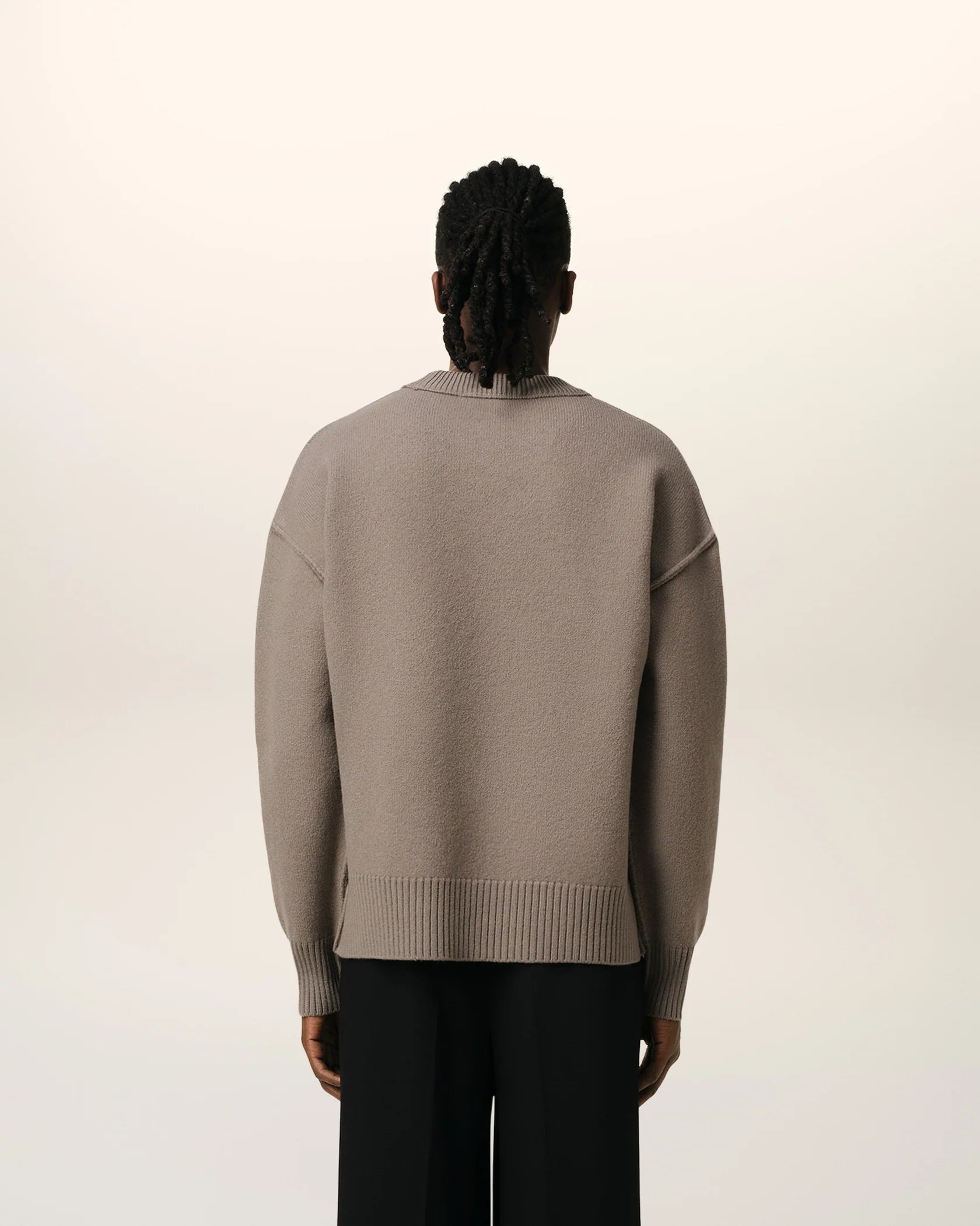 Brown sweater with a logo on a beige background