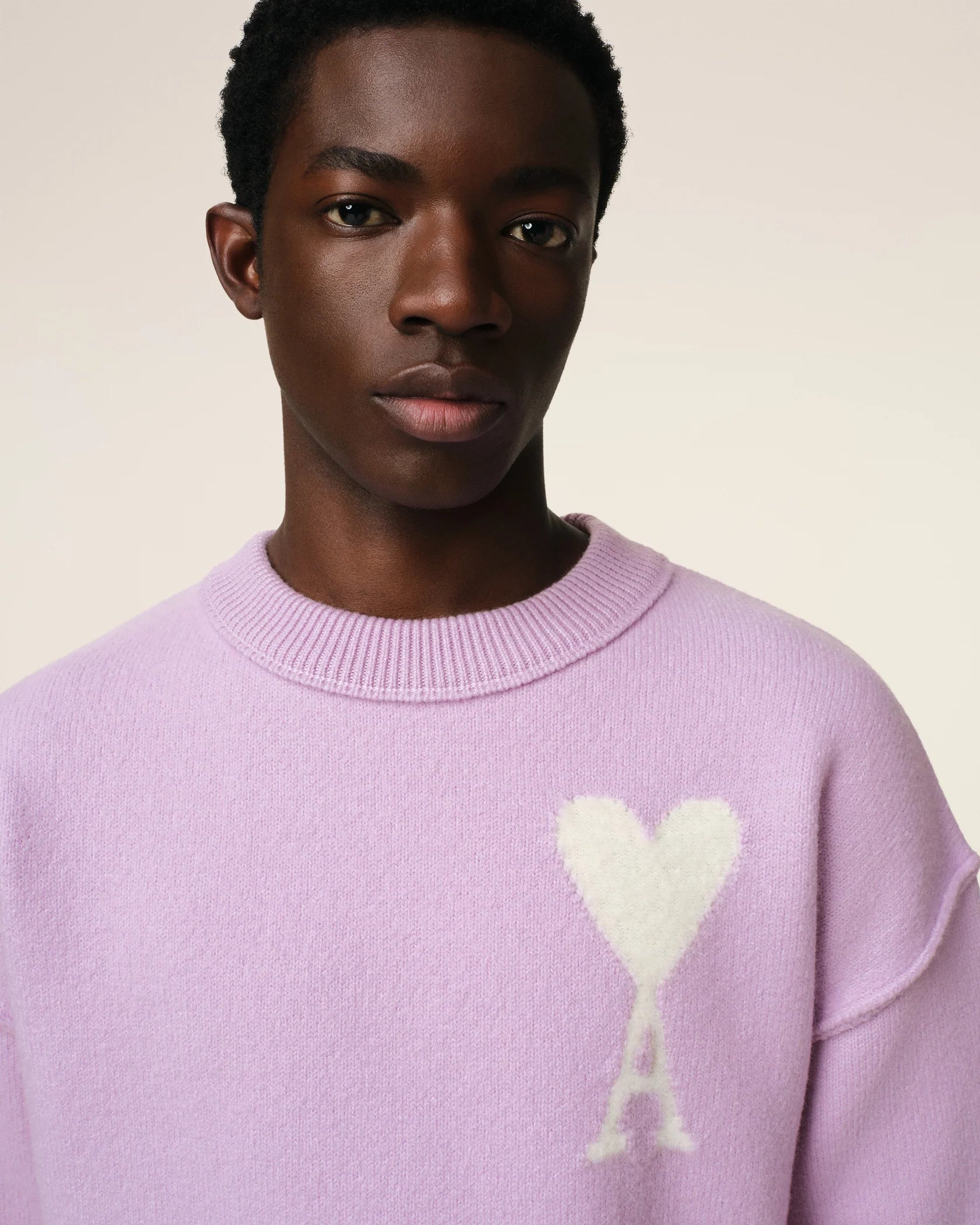 Lavender sweater with a heart design on a light beige background