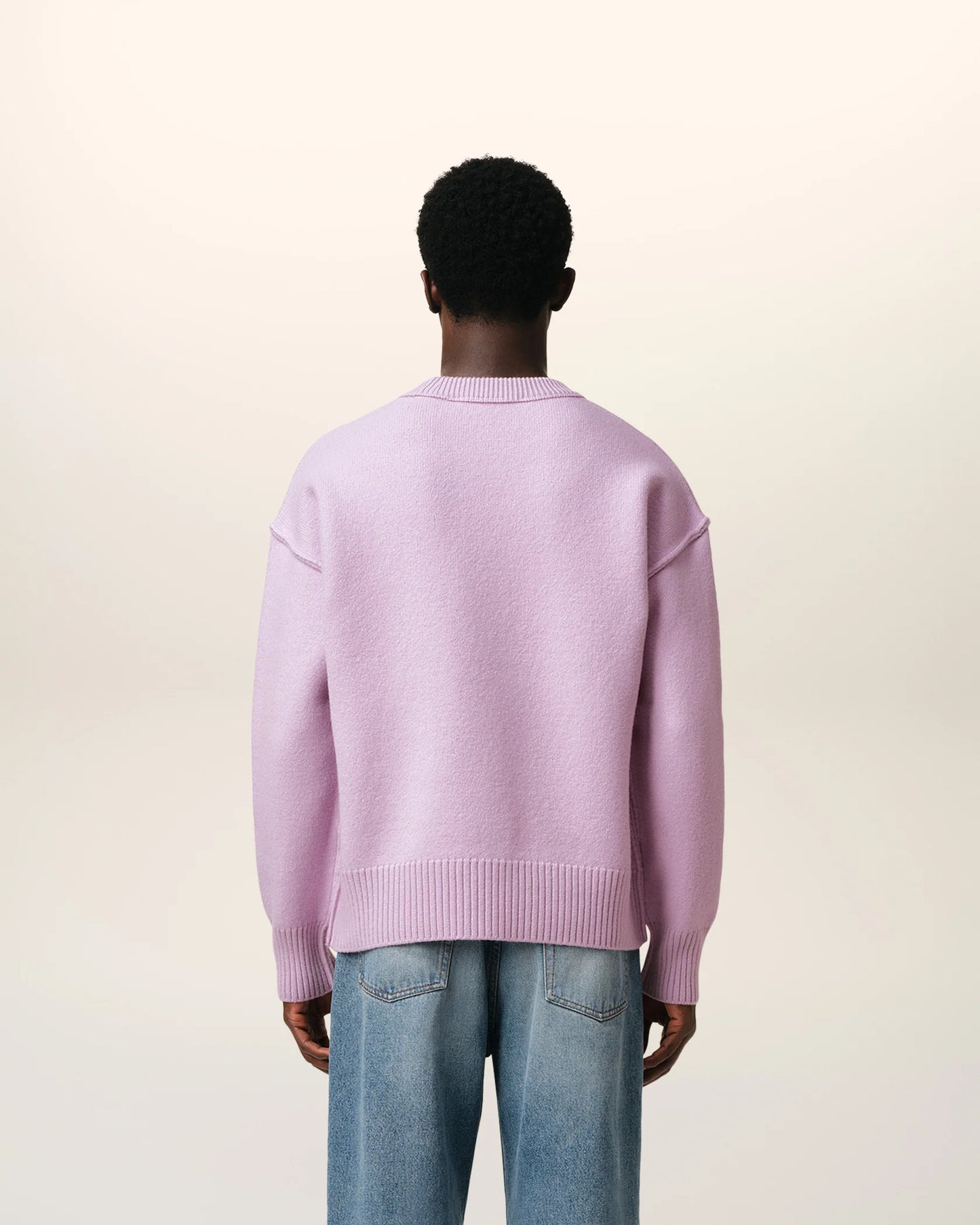 Lavender sweater with a heart design on a light beige background
