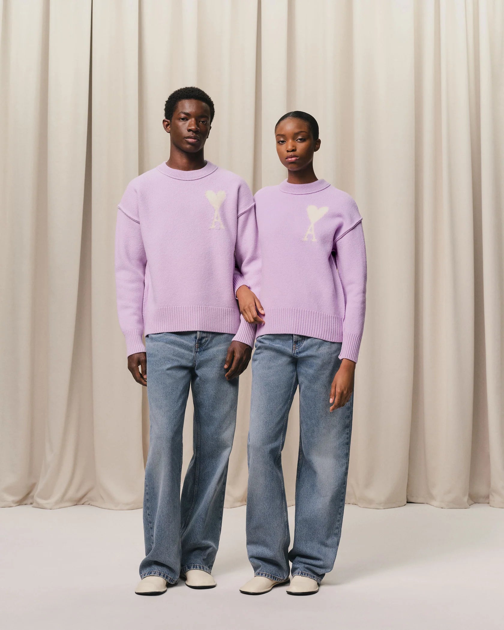 Lavender sweater with a heart design on a light beige background