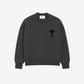 Gray sweater with a black heart and letter 'A' design on a beige background