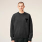 Gray sweater with a black heart and letter 'A' design on a beige background
