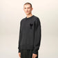 Gray sweater with a black heart and letter 'A' design on a beige background