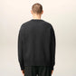 Gray sweater with a black heart and letter 'A' design on a beige background