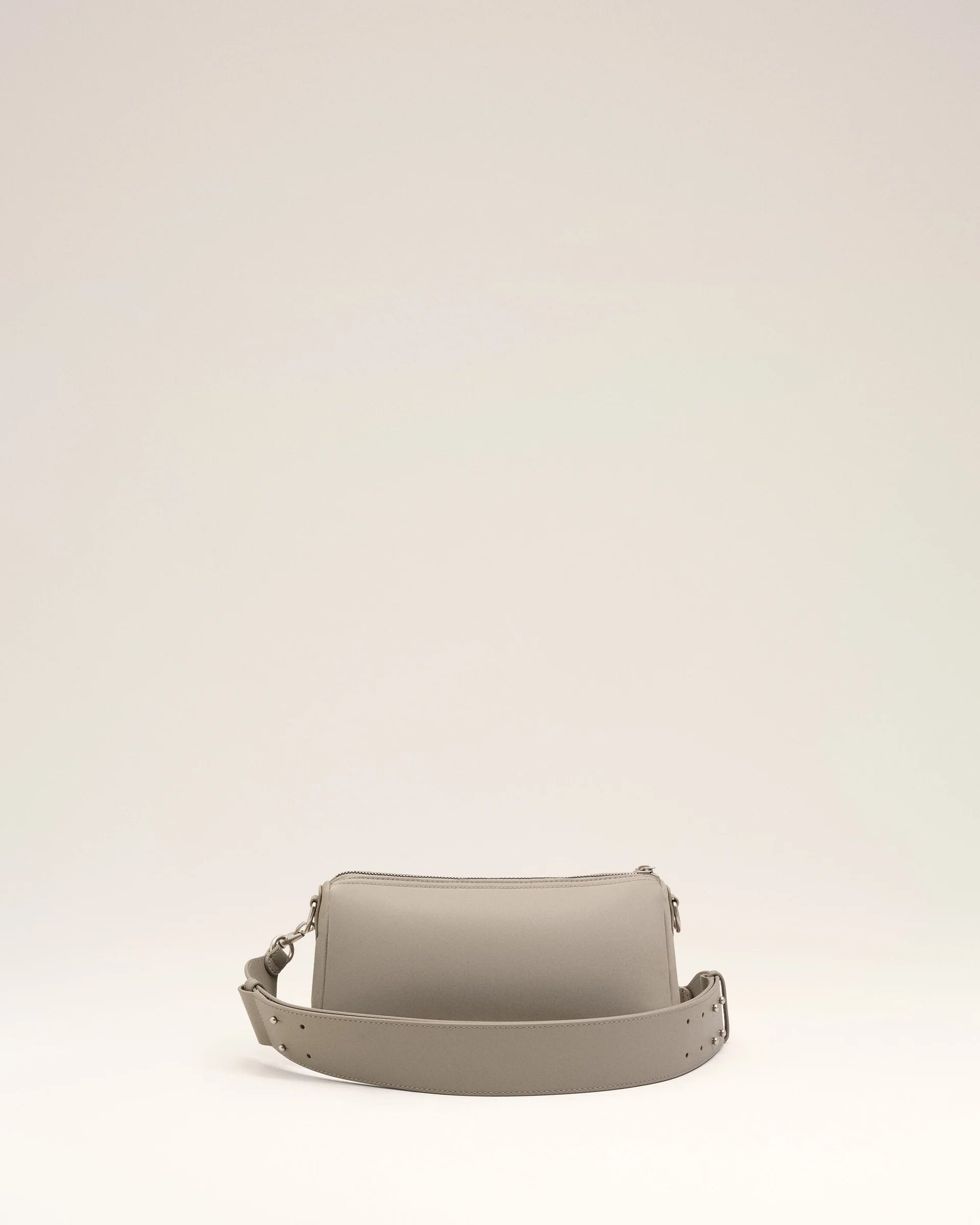 Light gray handbag with a heart detail on a light beige background ami paris