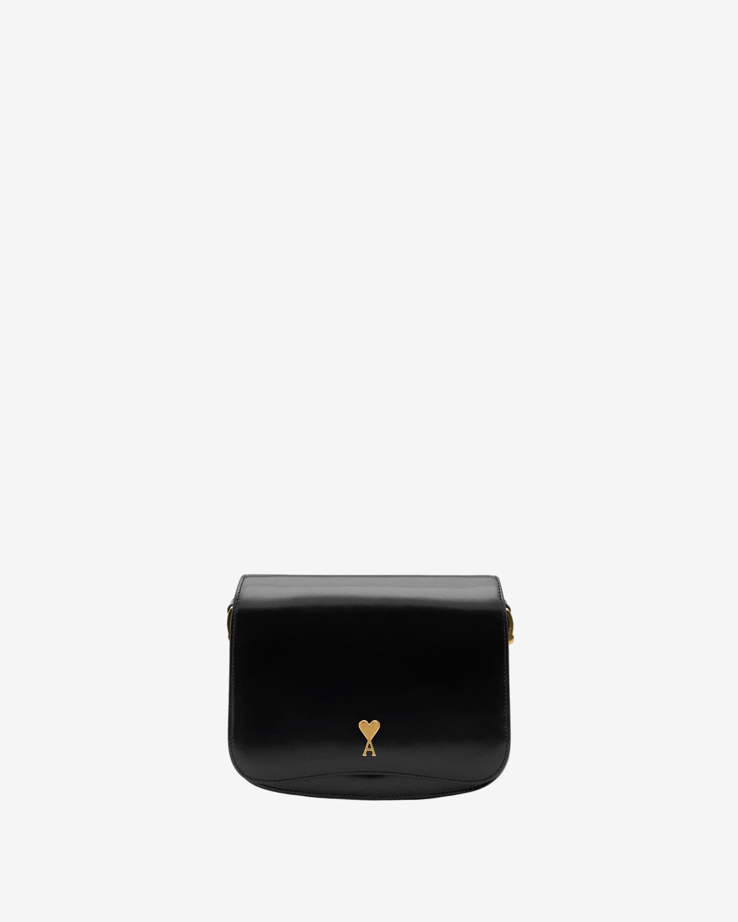 Black leather bag with a gold heart detail on a beige background