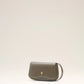 Green handbag with a gold heart emblem on a light beige background ami paris