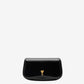 Person holding a black handbag with a gold emblem against a neutral background ami paris