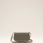 Green handbag with a silver flap on a light beige background green