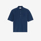 Navy blue polo shirt with a small logo on a beige background ami paris