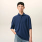 Navy blue polo shirt with a small logo on a beige background ami paris